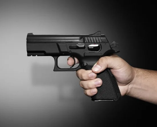 Pistol i hand Copyright: Adolfolazo/Dreamstime.com