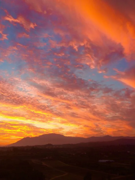 Den nedåtgående solen över Andaluciens berg bildar eldsflammor på  himlen.